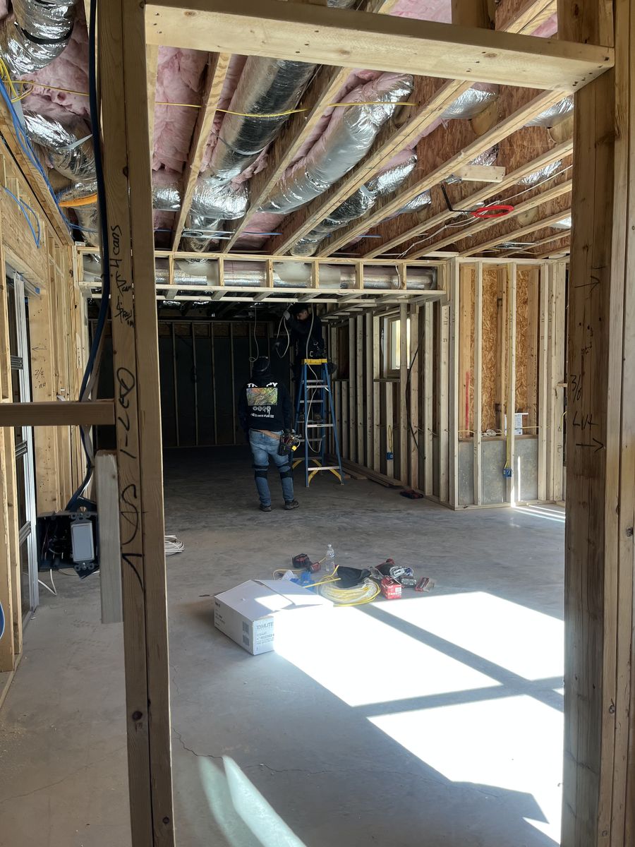 Basement build-out during framing, with stud walls, insulated ductwork and a bare concrete floor