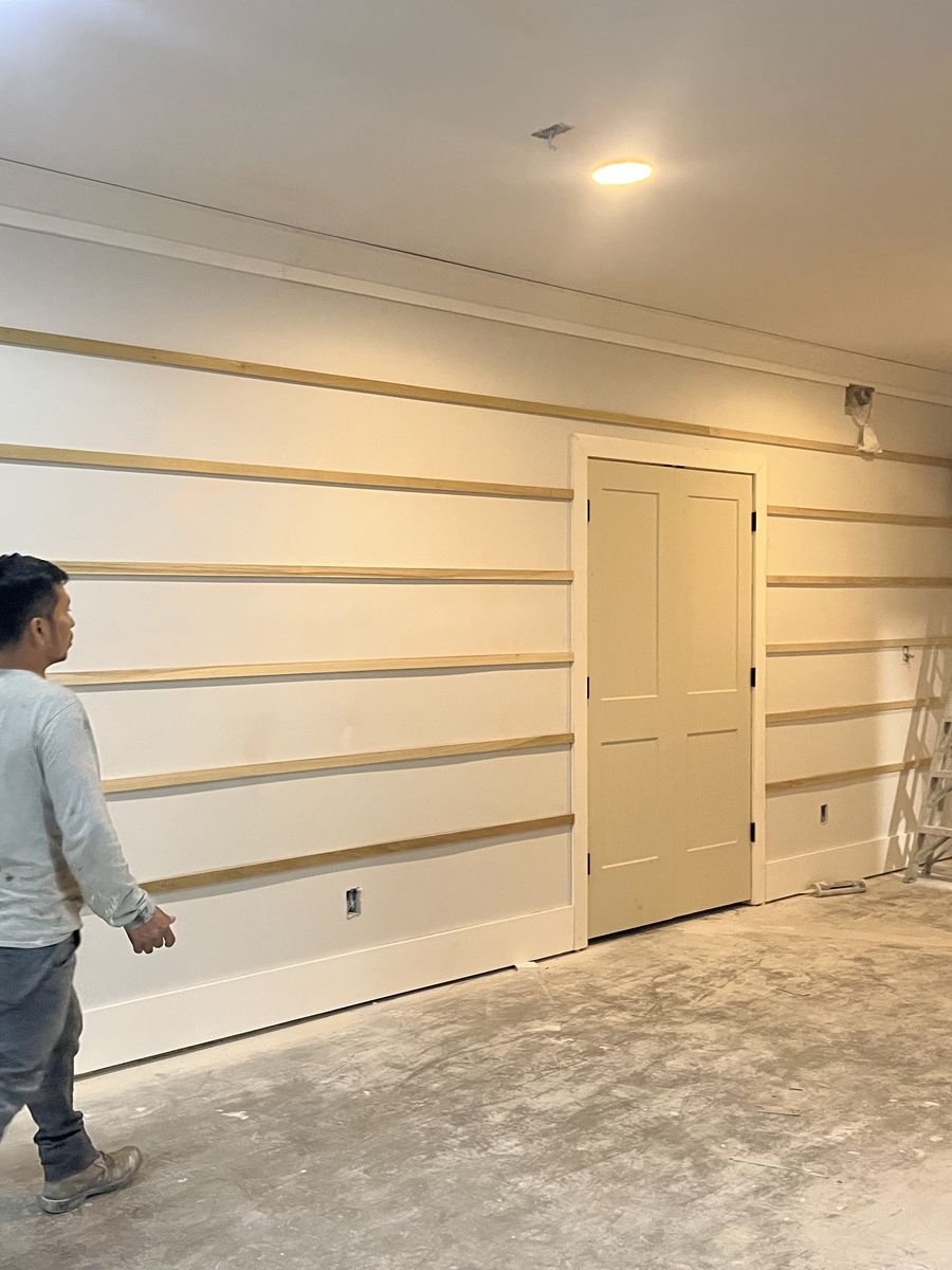 Basement build-out with finished drywall, shiplap trim boards, painted door and recessed lights