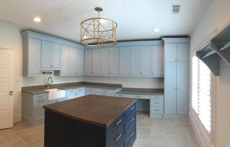 Custom pastel-blue Shaker cabinets, navy island and tile flooring