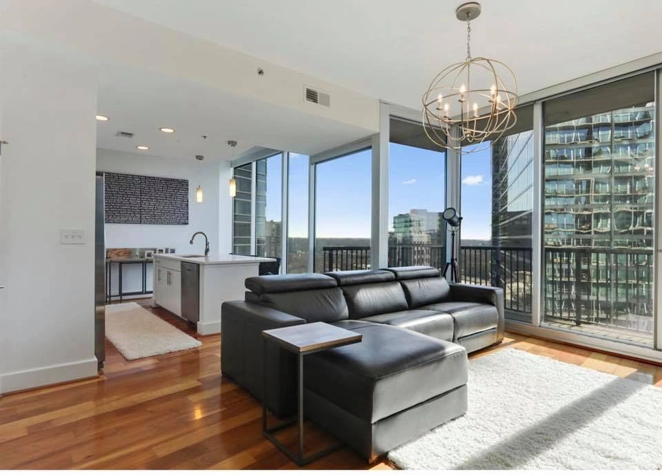 Open-concept condo living room and kitchen with hardwood floors