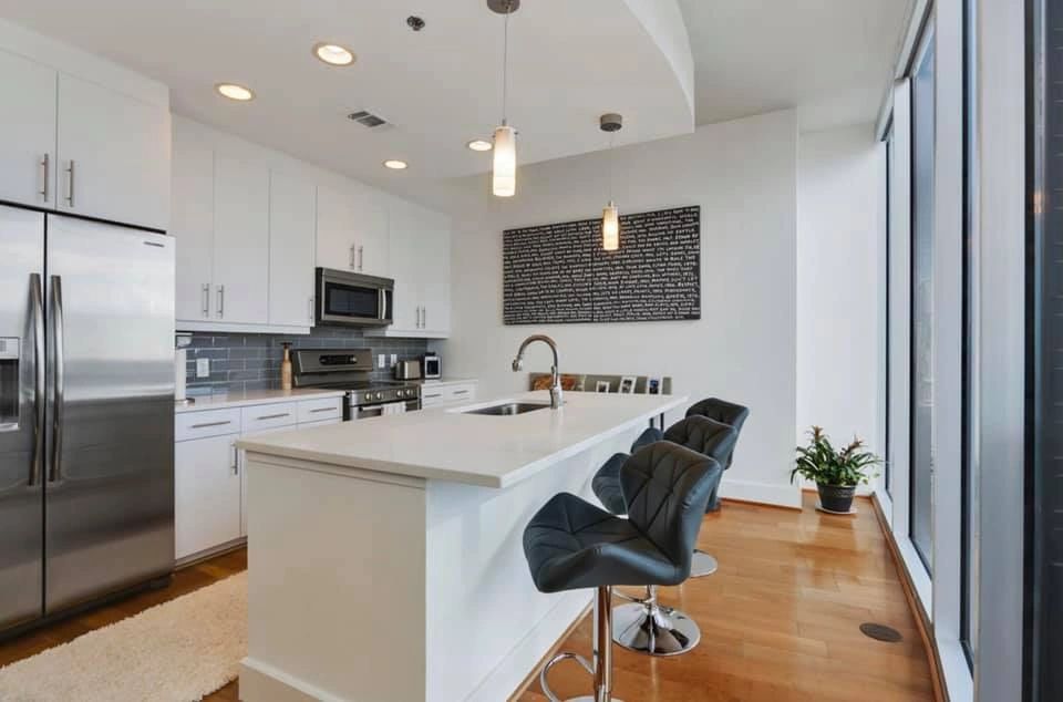 Modern white kitchen with waterfall island and wood floors